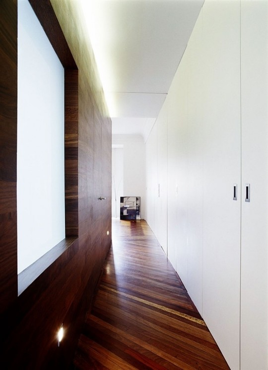 Un couloir avec des murs blancs et des murs en bois