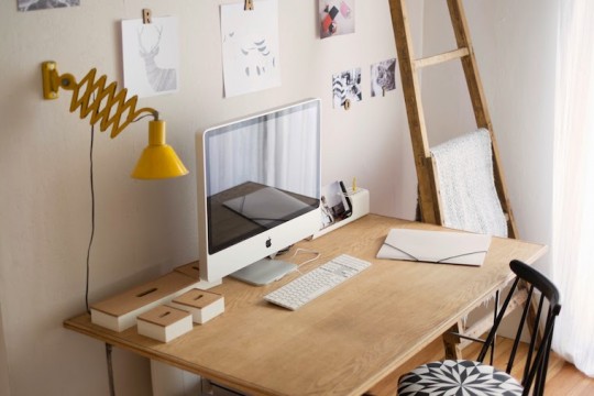 Bureau vintage en bois avec une lampe jaune et un iMac