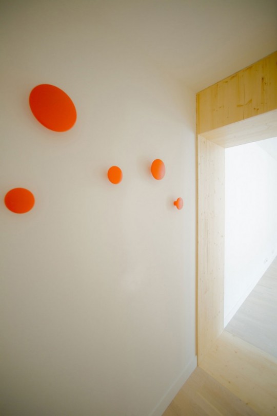 Cadre de porte en bois et patères rondes de couleur orange