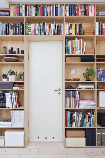 Bibliothèque aménagée autour de la porte d'un appartement