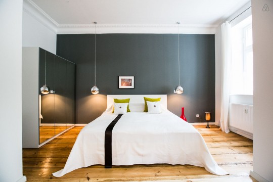 Chambre avec un mur gris et un parquet massif