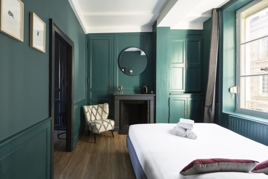 Chambre avec une cheminée et un miroir rond