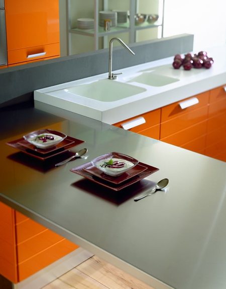 plan de travail gris qui contraste avec le orange de la cuisine ELITE